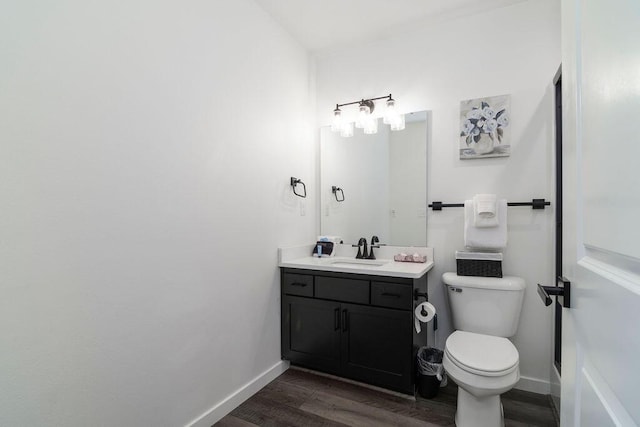 bathroom featuring baseboards, wood finished floors, and vanity