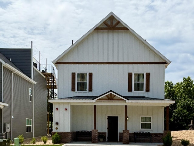 modern farmhouse style home featuring stairway, board and batten siding, metal roof, and a standing seam roof