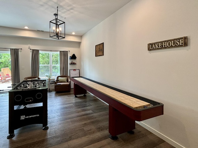 game room with baseboards, a healthy amount of sunlight, dark wood finished floors, and an inviting chandelier