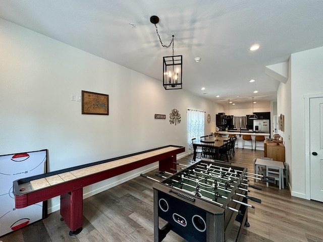 playroom with a notable chandelier, recessed lighting, wood finished floors, and baseboards