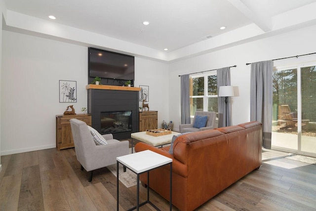 living room with visible vents, a glass covered fireplace, hardwood / wood-style floors, recessed lighting, and baseboards