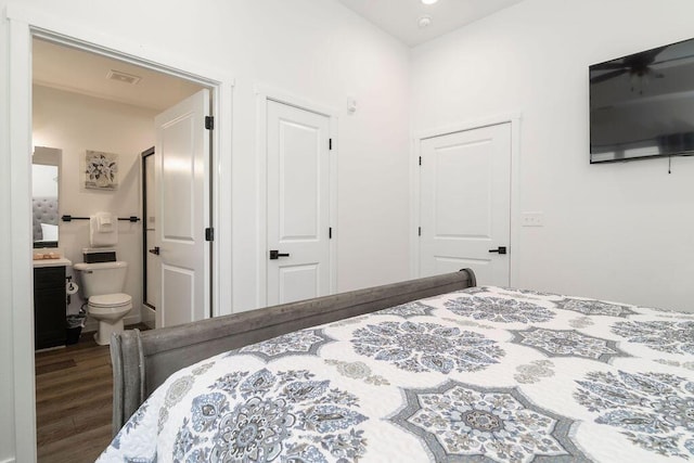 bedroom featuring wood finished floors, visible vents, and ensuite bathroom