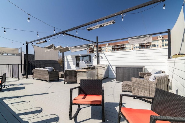 view of patio / terrace with a wooden deck, an outdoor kitchen, outdoor lounge area, and fence