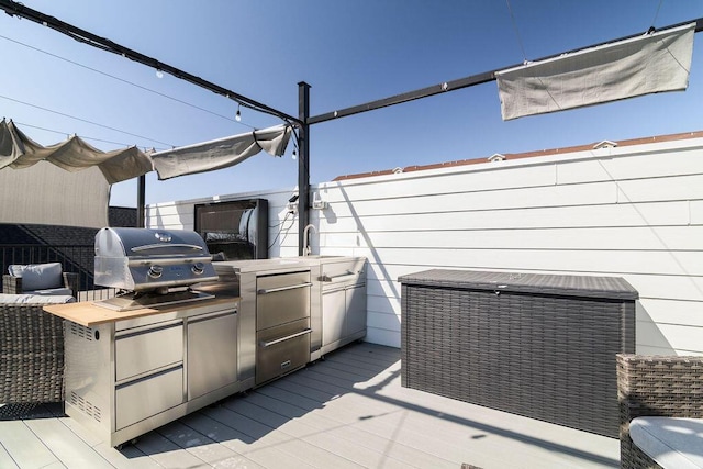 wooden terrace featuring a sink, area for grilling, and an outdoor kitchen