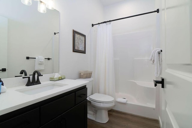 bathroom featuring a shower with shower curtain, toilet, wood finished floors, and vanity