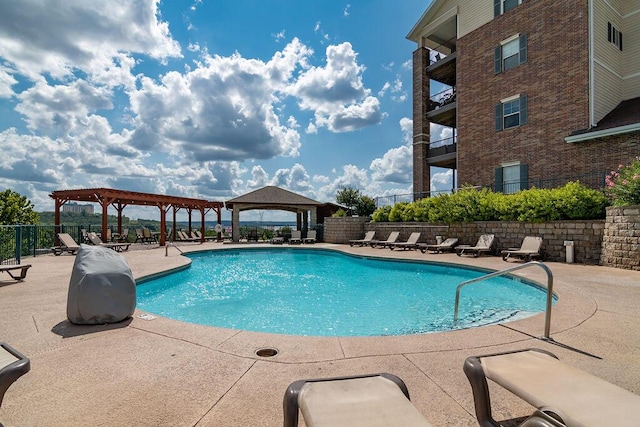 pool with a gazebo, a patio area, a pergola, and fence