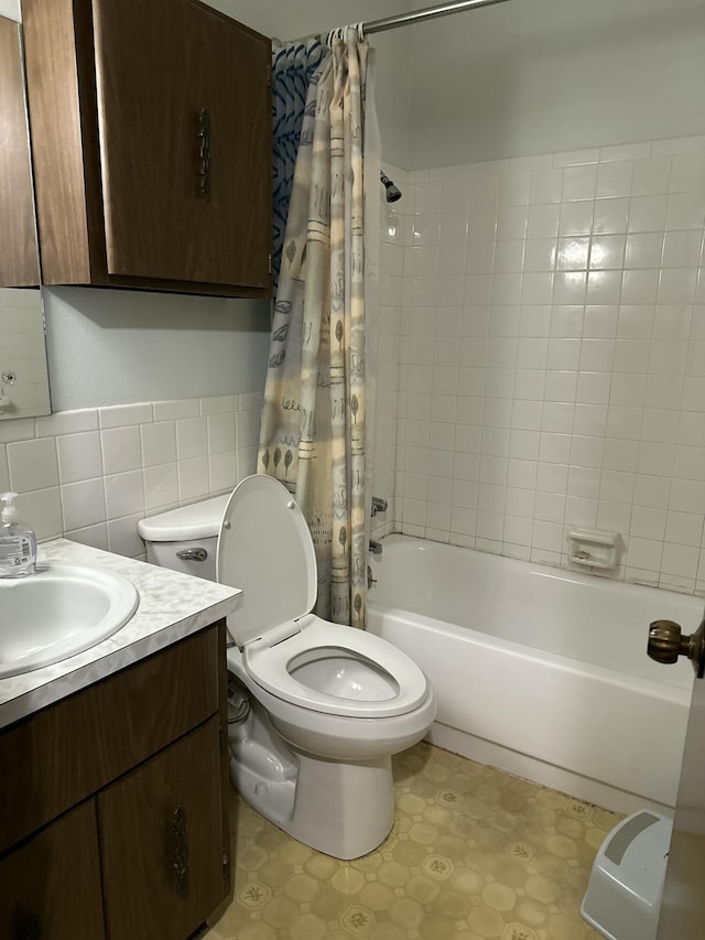 full bathroom with toilet, vanity, tile patterned floors, shower / bath combination with curtain, and tile walls