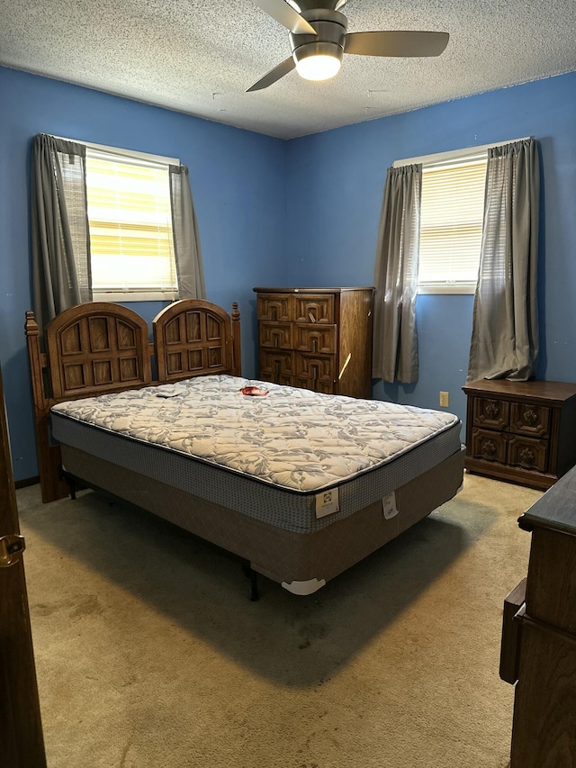 carpeted bedroom with a textured ceiling and ceiling fan