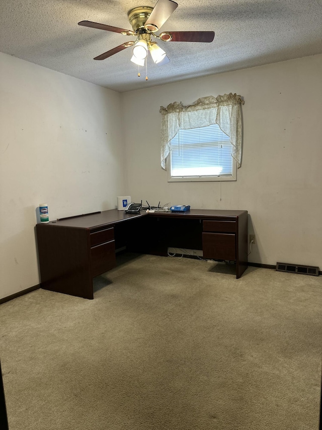 carpeted office featuring visible vents, baseboards, a textured ceiling, and a ceiling fan