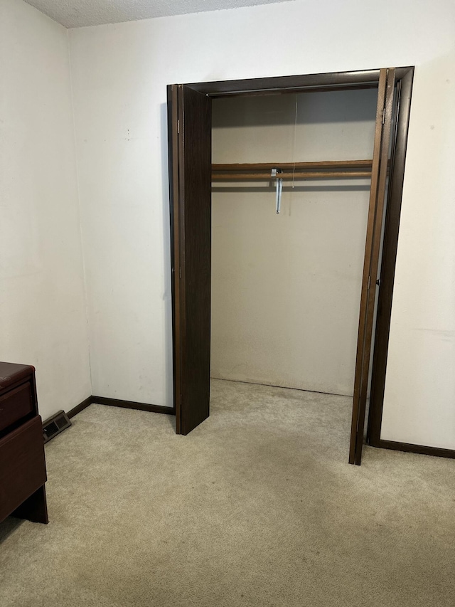 unfurnished bedroom with a closet, a textured ceiling, and carpet