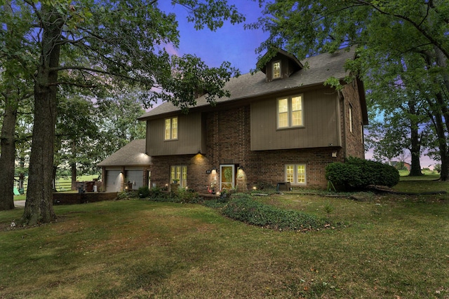 view of front of home with a garage, brick siding, and a front lawn