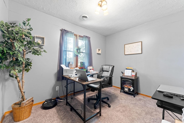 office area featuring carpet flooring, baseboards, visible vents, and a textured ceiling