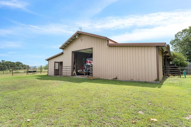 view of pole building with fence and a lawn