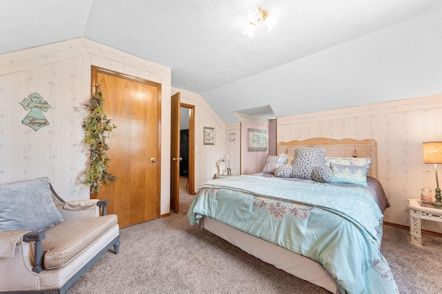 carpeted bedroom featuring wallpapered walls, lofted ceiling, and a textured ceiling