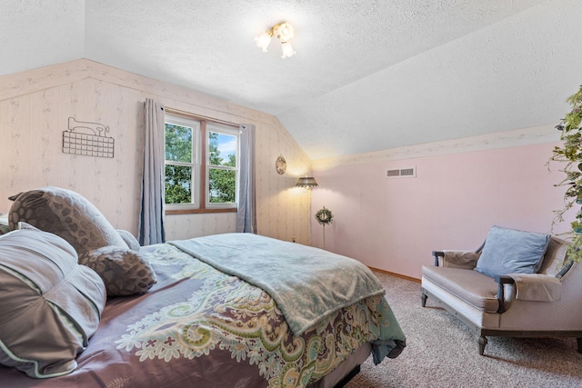 carpeted bedroom featuring visible vents, lofted ceiling, and a textured ceiling