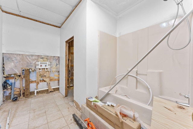 bathroom with a drop ceiling and a tub to relax in