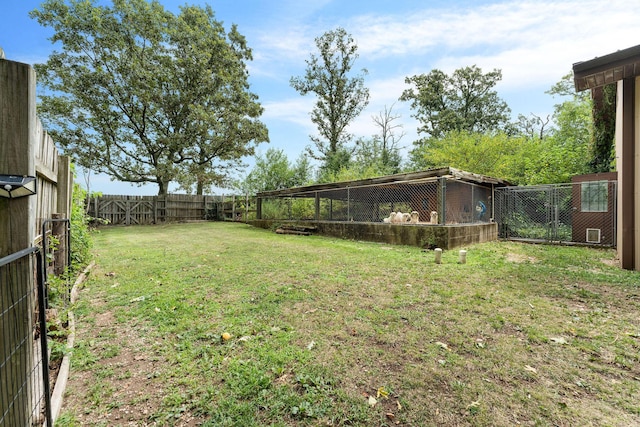 view of yard featuring exterior structure, an outdoor structure, and a fenced backyard