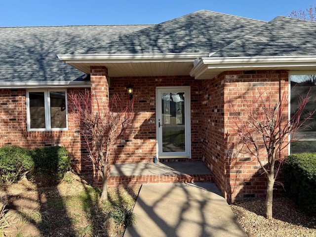 property entrance with brick siding and roof with shingles