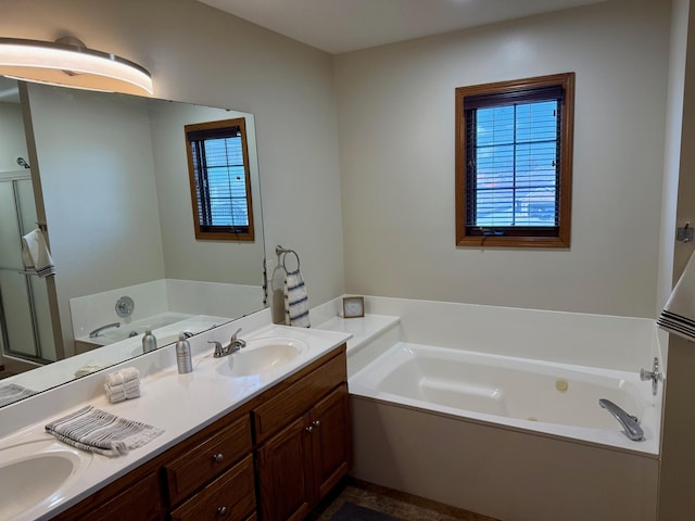 bathroom with a garden tub, double vanity, and a sink