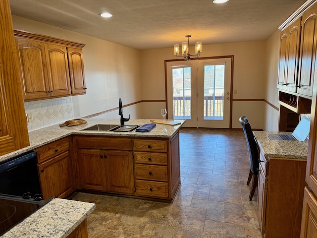 kitchen featuring a sink, light stone counters, black dishwasher, a peninsula, and brown cabinetry