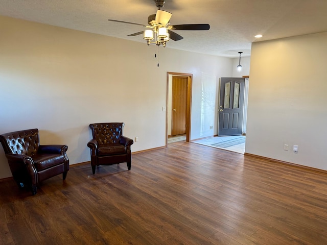 sitting room with baseboards, ceiling fan, and wood finished floors