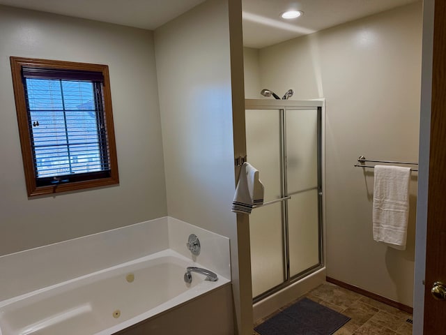 bathroom with a tub with jets, recessed lighting, a stall shower, and baseboards