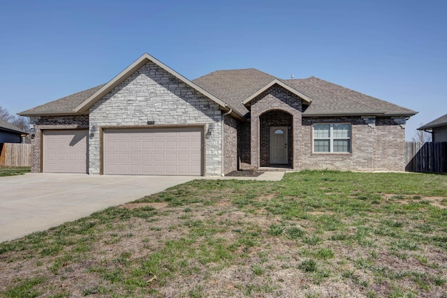 ranch-style house with fence, concrete driveway, a front yard, a shingled roof, and an attached garage