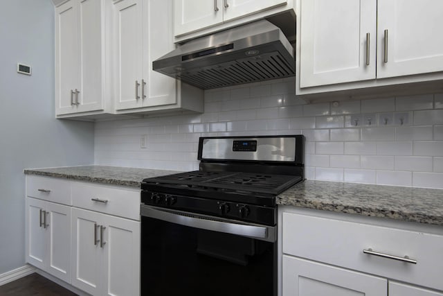 kitchen with under cabinet range hood, gas range, backsplash, and white cabinetry