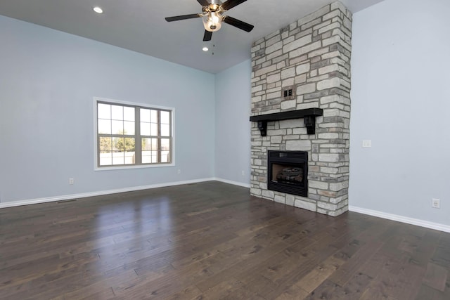 unfurnished living room featuring wood finished floors, a ceiling fan, baseboards, recessed lighting, and a stone fireplace