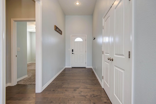 entryway with dark wood-type flooring and baseboards