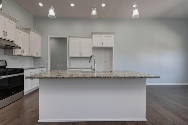 kitchen with stainless steel gas range oven, an island with sink, under cabinet range hood, a sink, and white cabinets