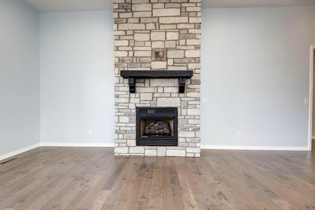 unfurnished living room with baseboards, wood finished floors, and a fireplace