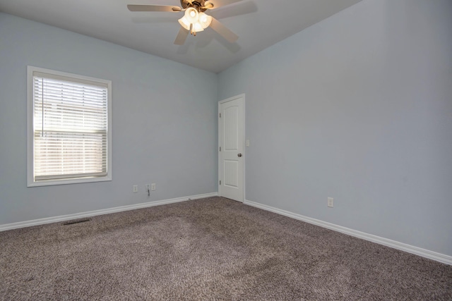 carpeted empty room with visible vents, a ceiling fan, and baseboards