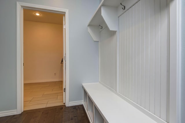 mudroom with dark wood finished floors and baseboards