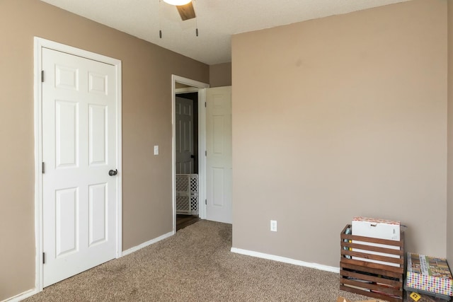 unfurnished bedroom featuring carpet flooring, a ceiling fan, and baseboards