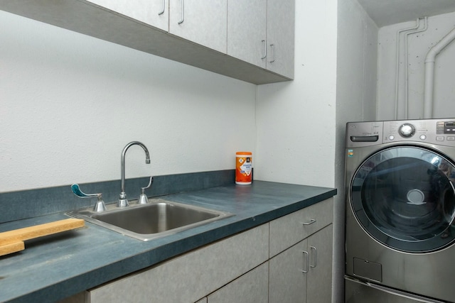 laundry area featuring cabinet space, washer / clothes dryer, and a sink