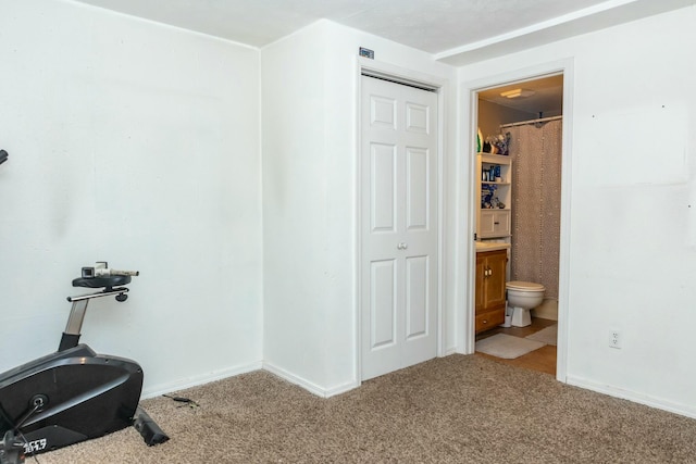 exercise room featuring baseboards and carpet floors