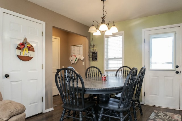 dining area featuring a notable chandelier and dark wood-style floors