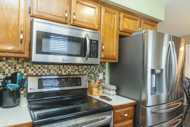 kitchen with light countertops, tasteful backsplash, brown cabinets, and appliances with stainless steel finishes