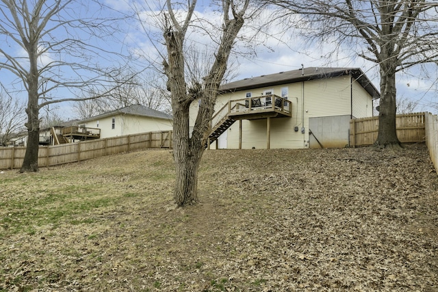 back of property with a deck, stairway, and a fenced backyard