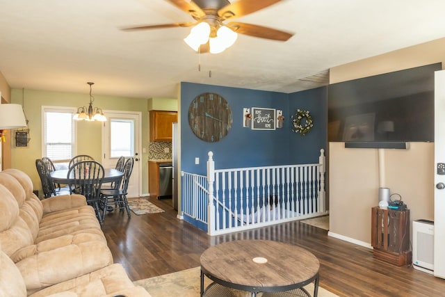 living room with baseboards, wood finished floors, and ceiling fan with notable chandelier