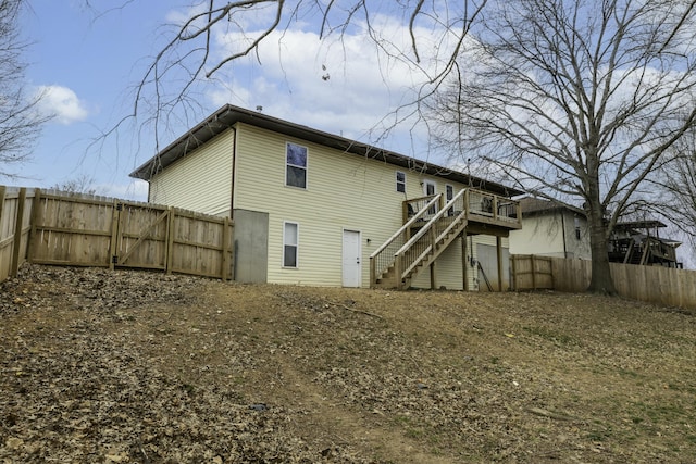 back of property with stairway, a fenced backyard, and a wooden deck