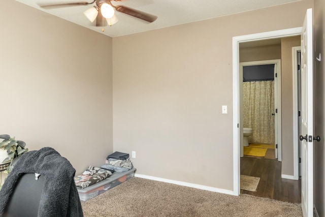 interior space with baseboards, carpet floors, and ceiling fan