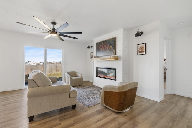 living room with baseboards, wood finished floors, and a fireplace