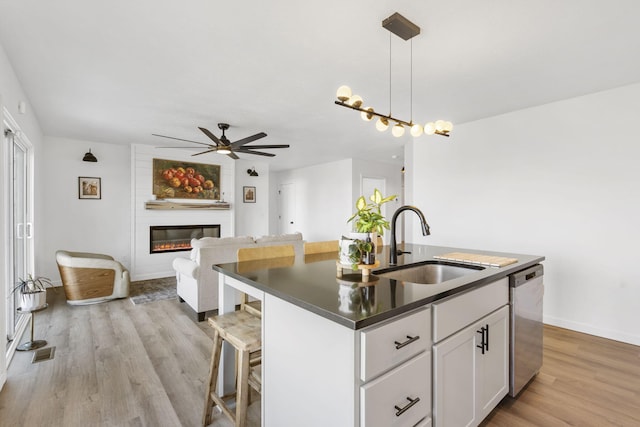 kitchen with visible vents, a kitchen island with sink, a sink, dishwasher, and ceiling fan