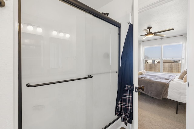 bathroom with a shower stall and ceiling fan