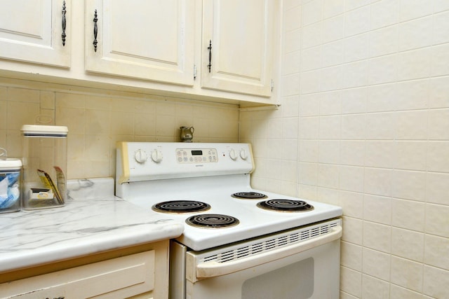 kitchen featuring tasteful backsplash, tile walls, and electric stove