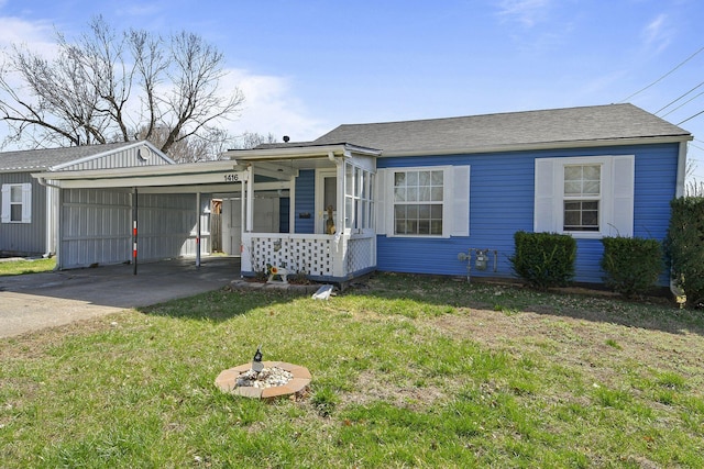 view of front facade with a carport, concrete driveway, a front yard, and a shingled roof