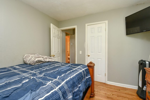 bedroom with light wood-style flooring and baseboards