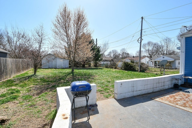 view of yard with a shed, a patio, an outdoor structure, and fence